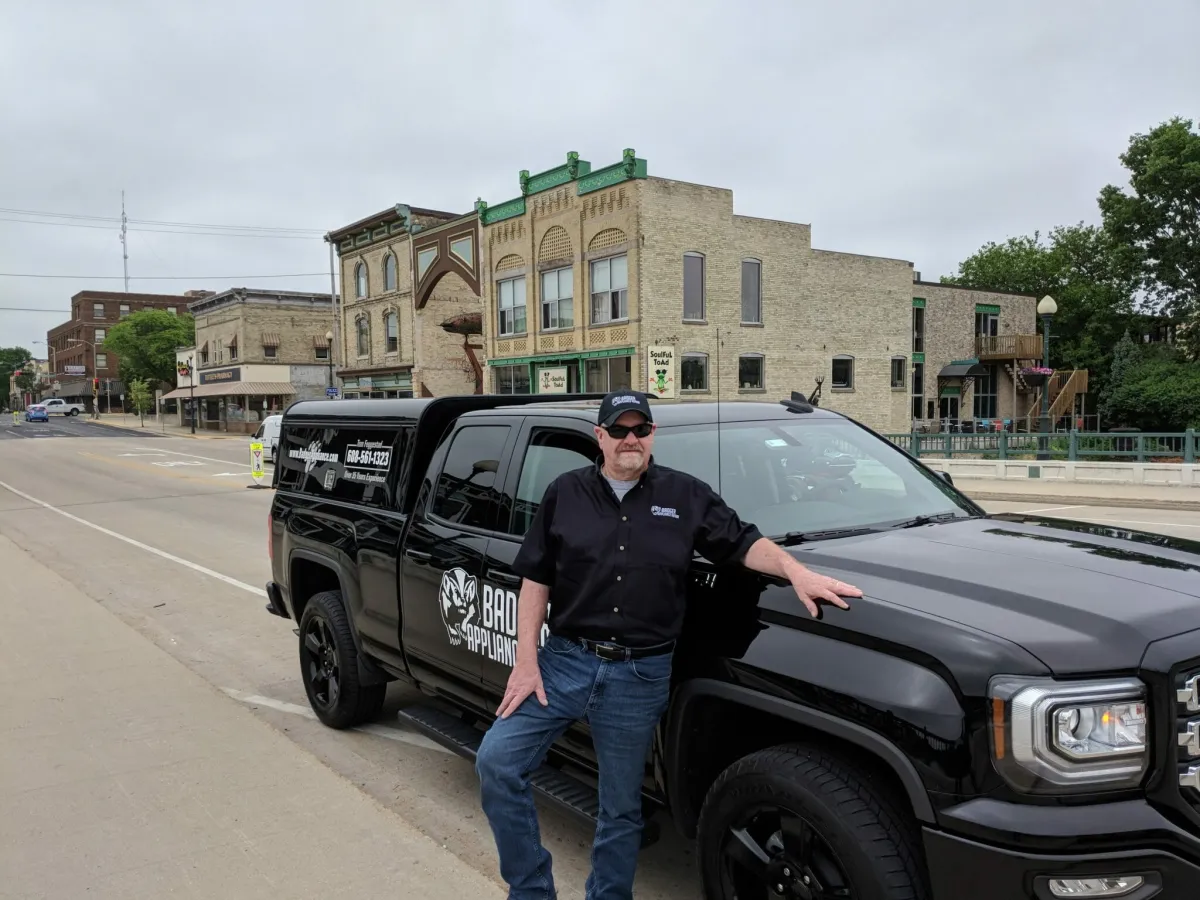 Tom Feggestad beside his black Badger Appliance Repair truck in downtown Fort Atkinson